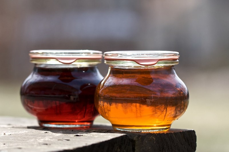 dark and amber maple syrup in glass bottles