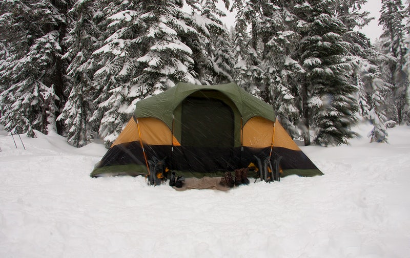 A green and orange tent for camping in the snow at Stevens Pass, Washington. 